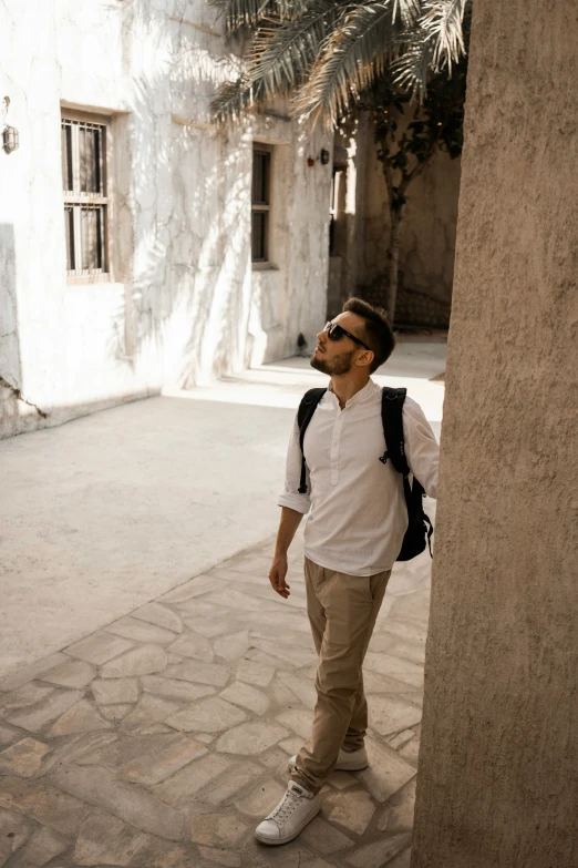 man looking up in the street by building