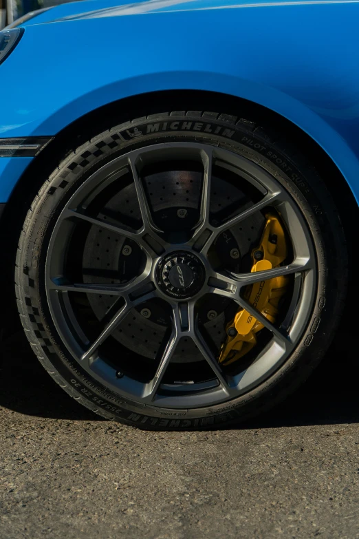 the wheel on a blue sports car with black spokes