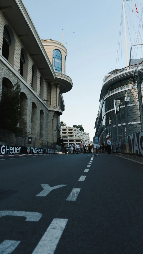 a sign is on a road as a building stands tall