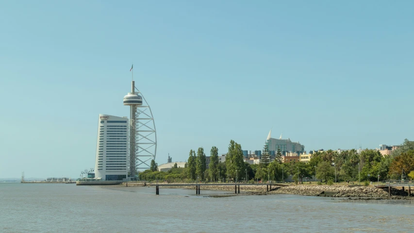 a lake with a small town and some tall buildings in the distance