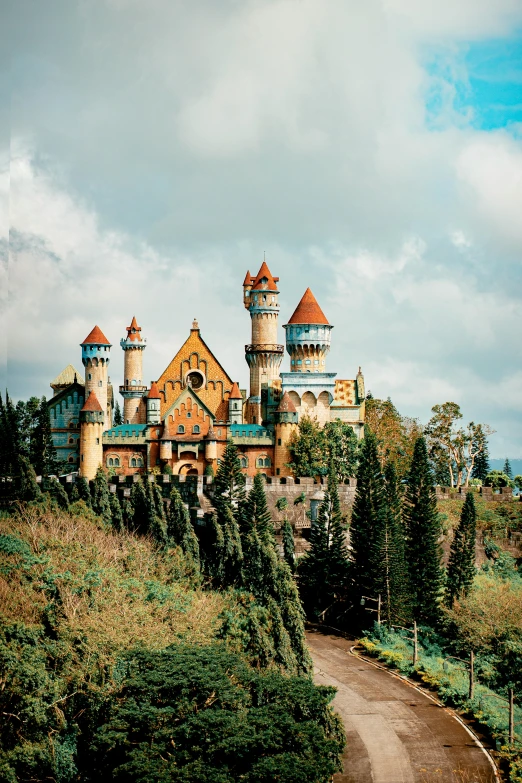 an ornate castle on top of a hill in the countryside