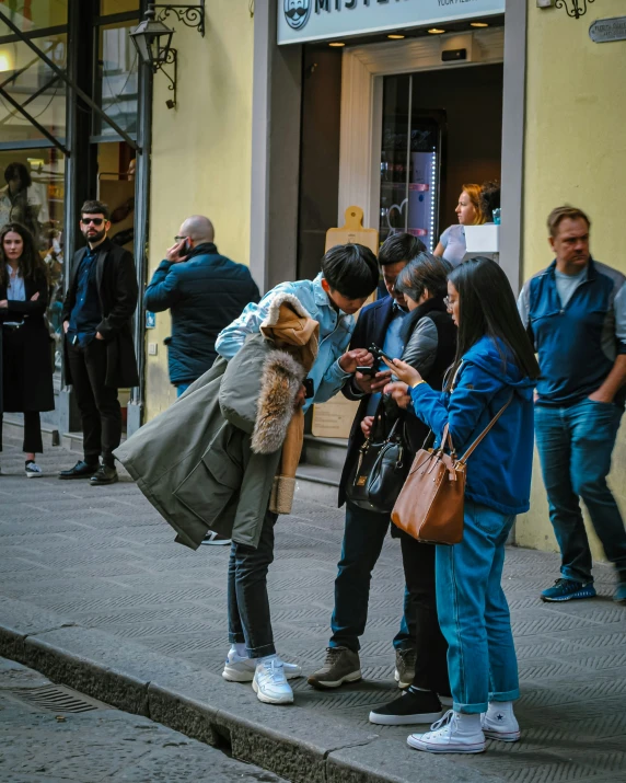 young people on the sidewalk checking their phones