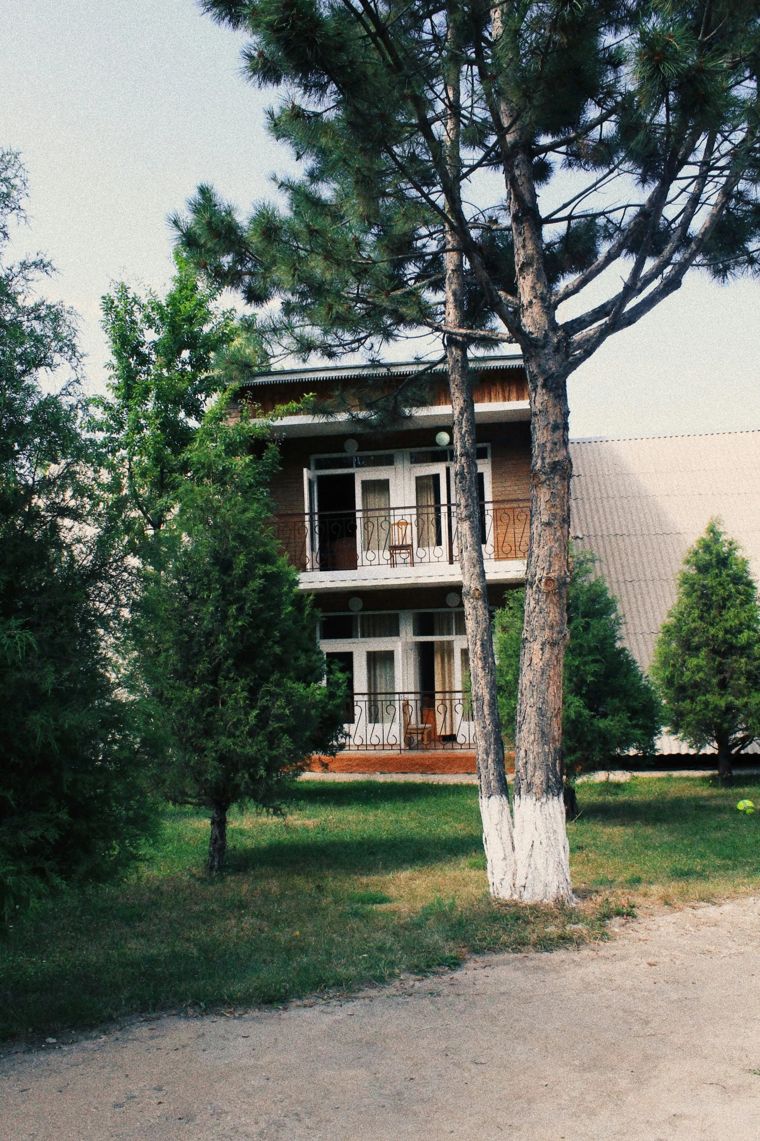 a house in the grass with trees around