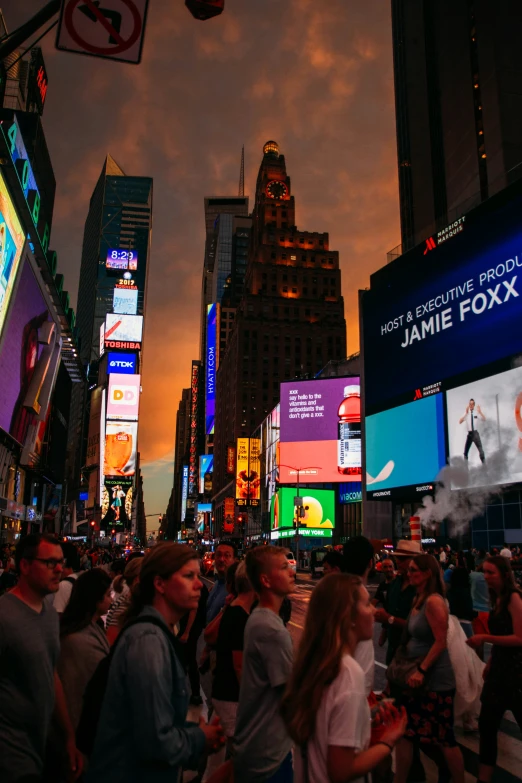 several people are walking in times square during the night