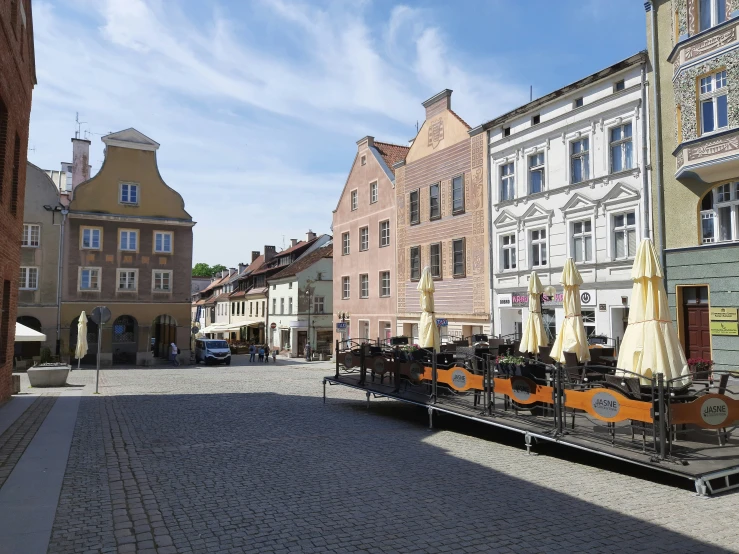 several buildings and an empty sidewalk in front of some parked cars