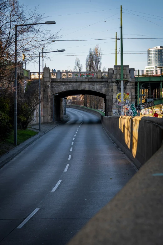 a view of a narrow bridge spanning an empty road