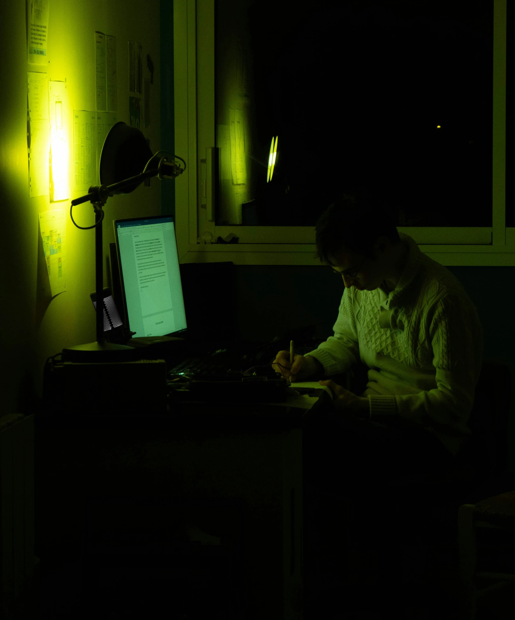 a person sitting at a desk writing on a laptop