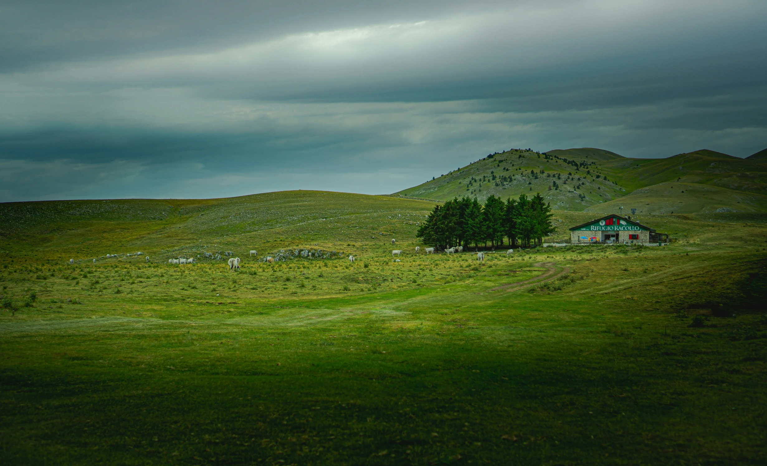 an old house sits on the green rolling hills