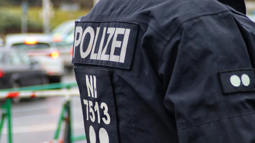 the policeman has on a uniform and is walking down a street