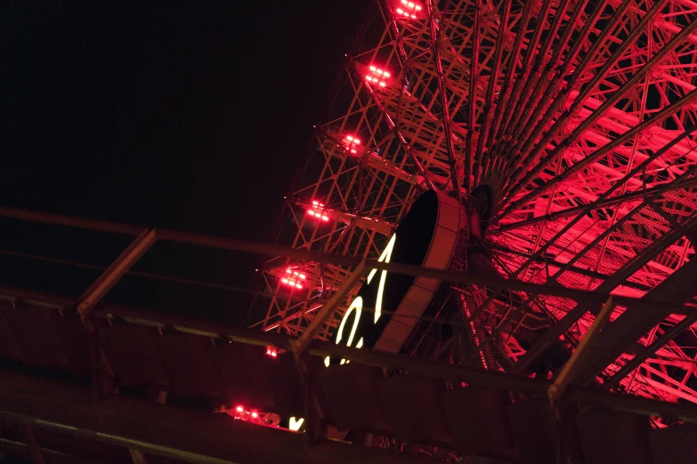 a red illuminated ferris wheel at night time