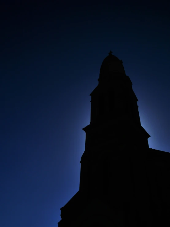 the moon shines brightly over the top of an old church