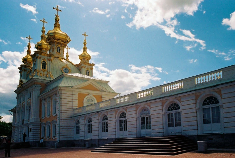 the building has many gold and white domes on it