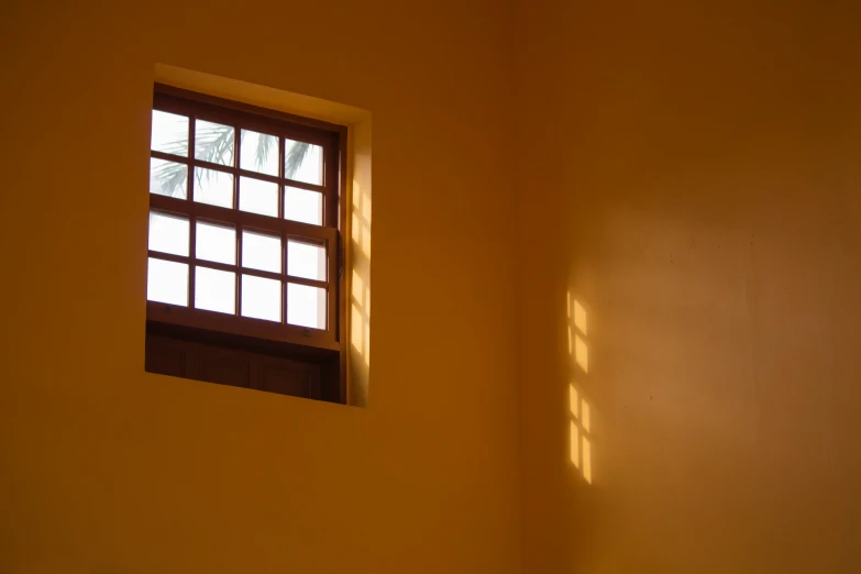 a bedroom with an open window and small white bed in the corner