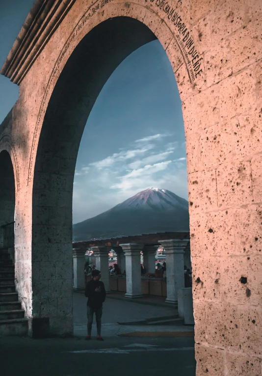 a man standing in a doorway to a temple with an archway between them