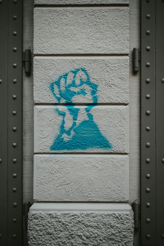 a wall with a drawing on it and a blue fist