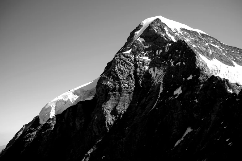 a snow covered mountain peak, against a black and white background