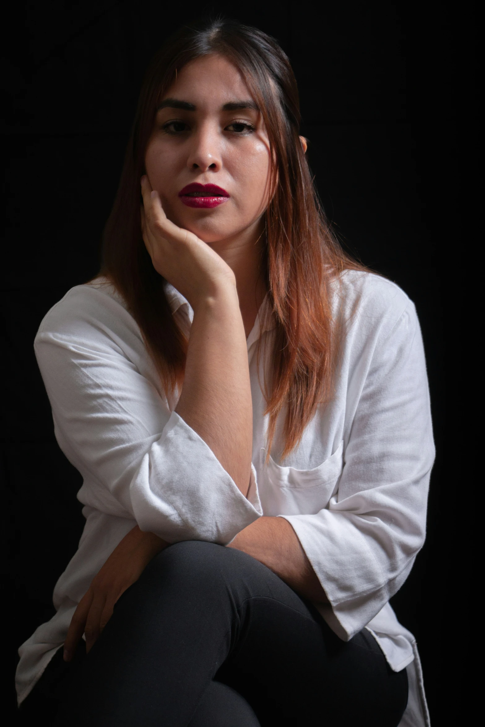 a beautiful woman with a red lip sitting and thinking