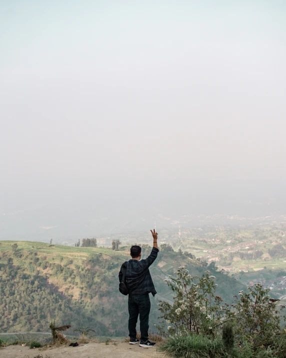 a man flying a kite at the top of a hill