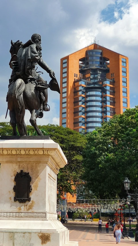 statue of a man on a horse with city in the background