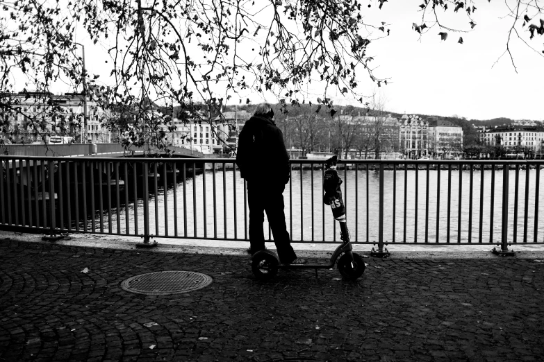 a man and a young child on skateboards are standing near the water