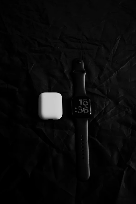 there is an unpacked watch and soap on a black cloth