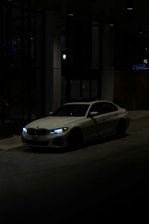 a white car is parked in the dark
