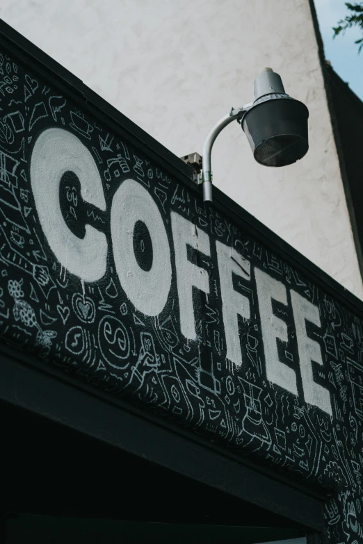 the corner sign for a coffee shop painted with black and white designs