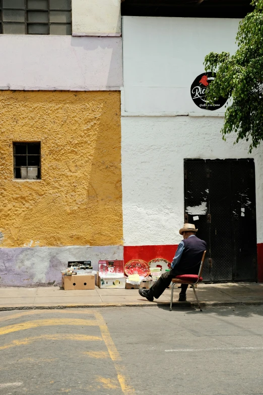 a man sitting on a bench in front of a wall