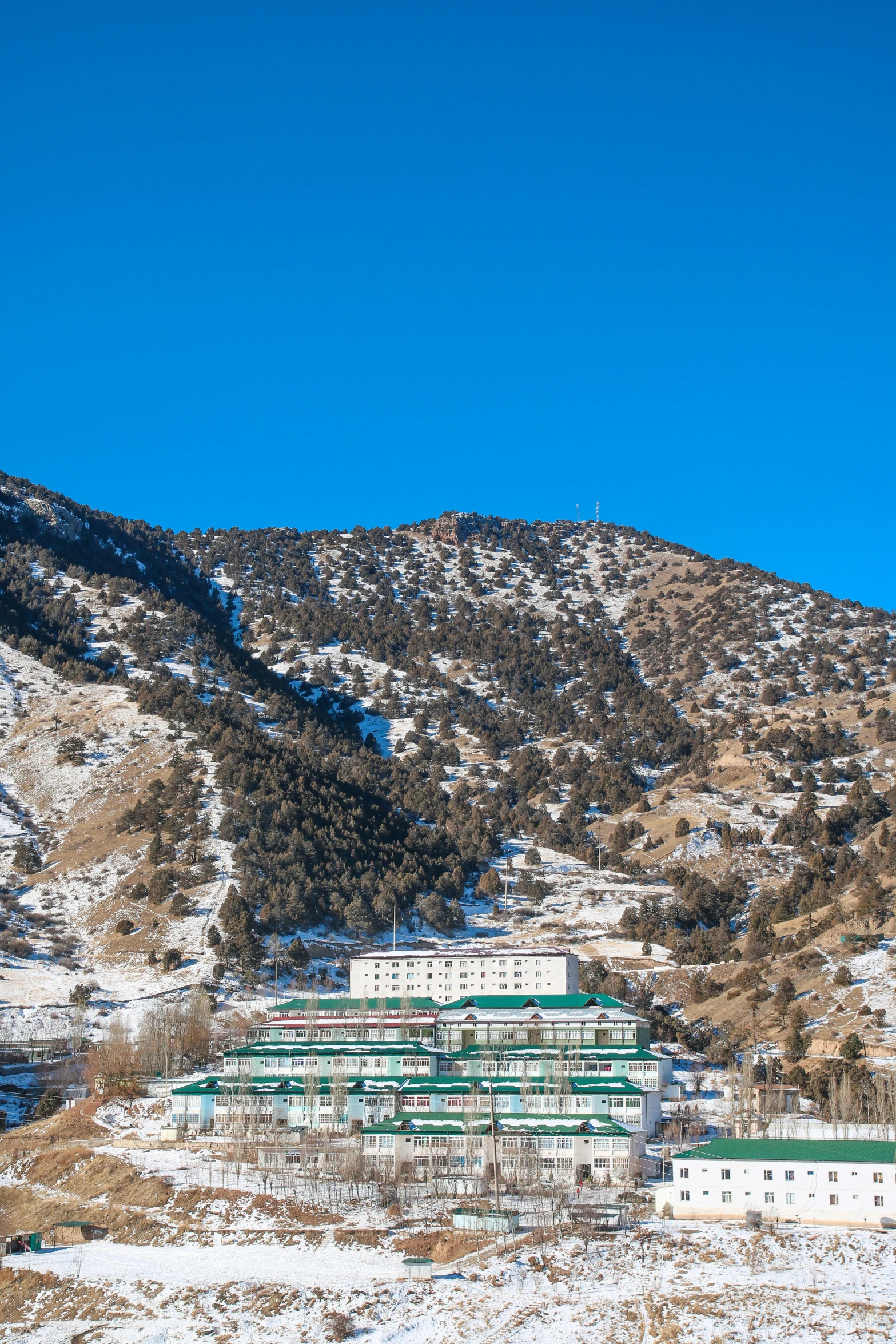 a large building in front of a snowy mountain