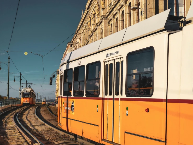 a view of some orange colored trains coming down the tracks