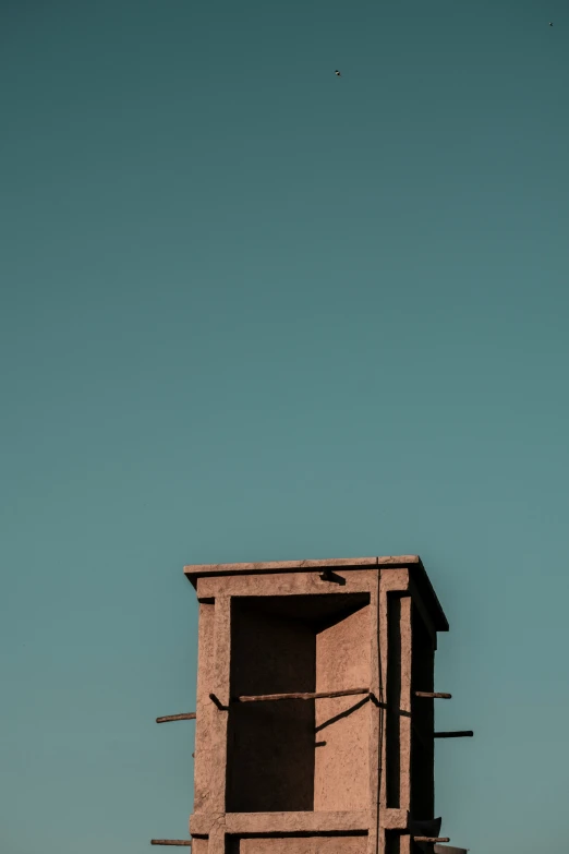 a bird sitting on a high perch in a building