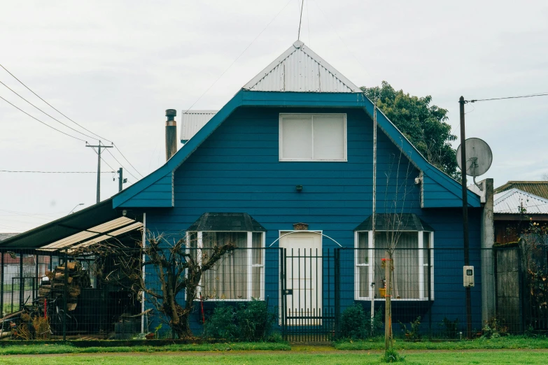 a blue house with a tall tower and blue fence