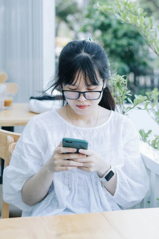 the woman is looking at her phone with interest