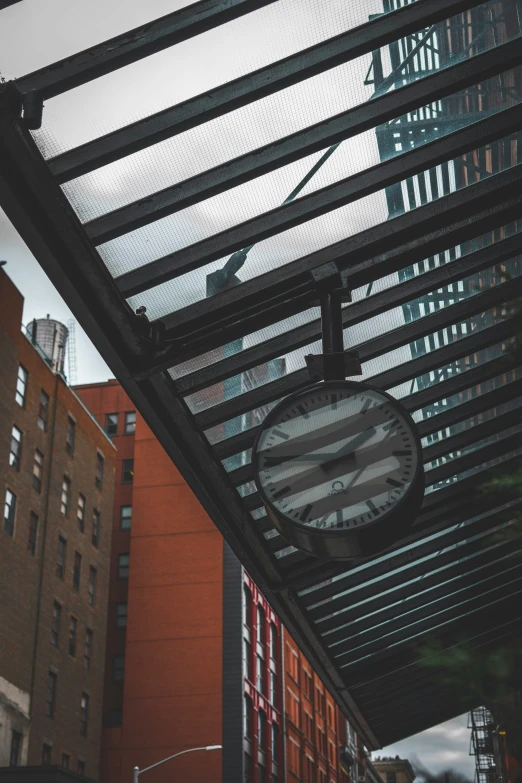 a clock at an elevated walkway in a city