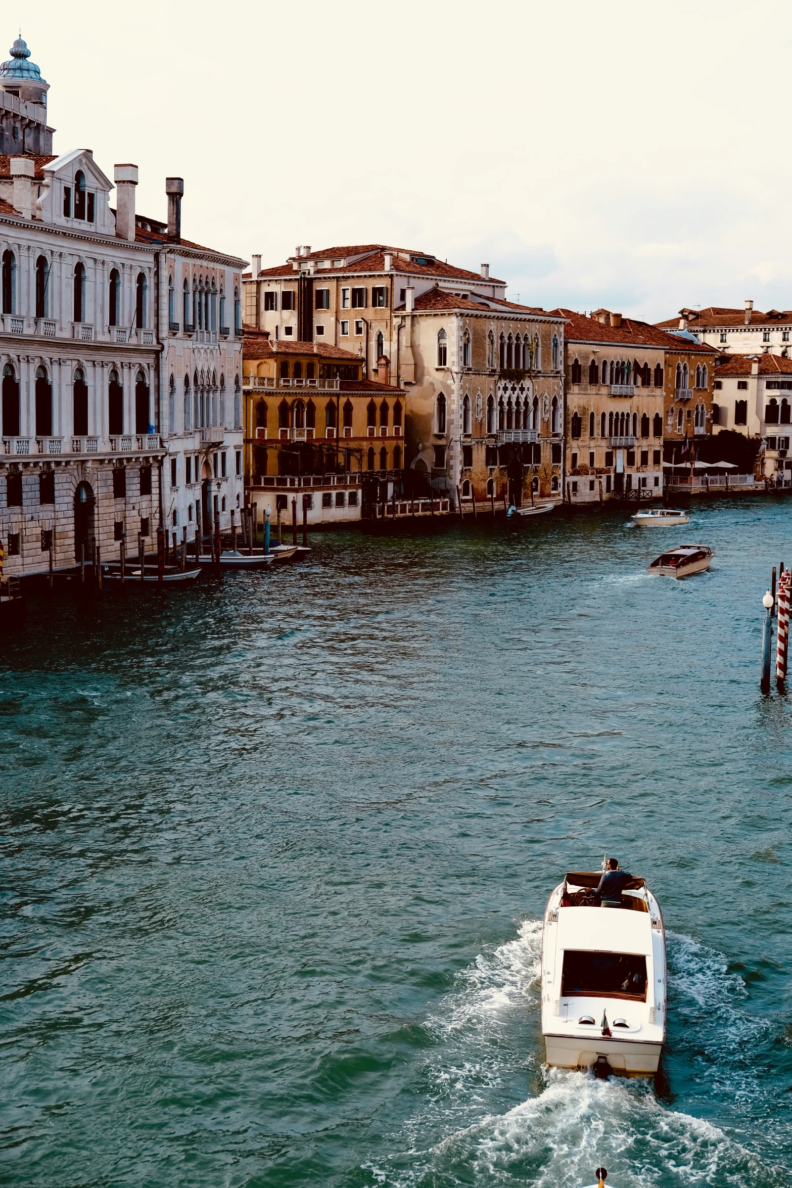 a boat traveling down a river past buildings