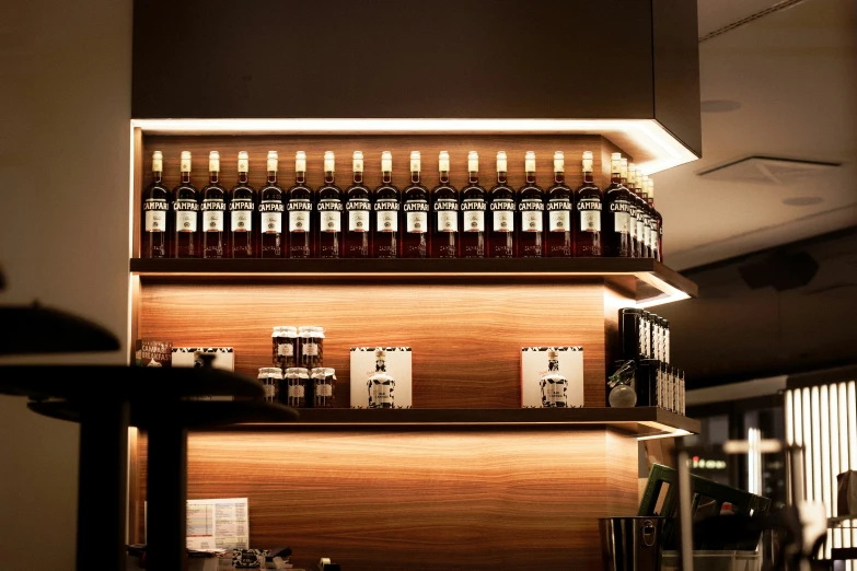 a line of bottles on a shelf with other bottles and glasses