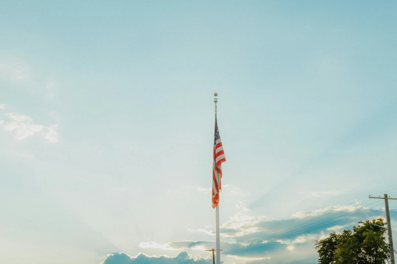 a tall flag is shown in the sky above some cars