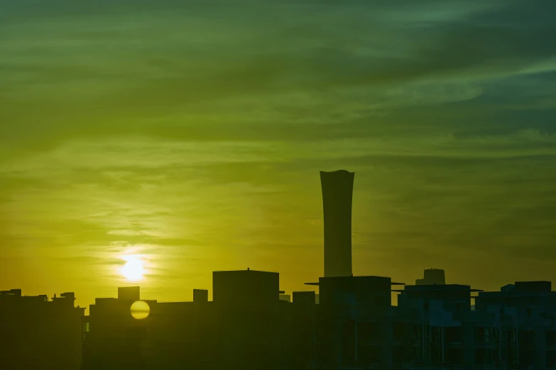 the sun is shining behind a silhouette of tall buildings