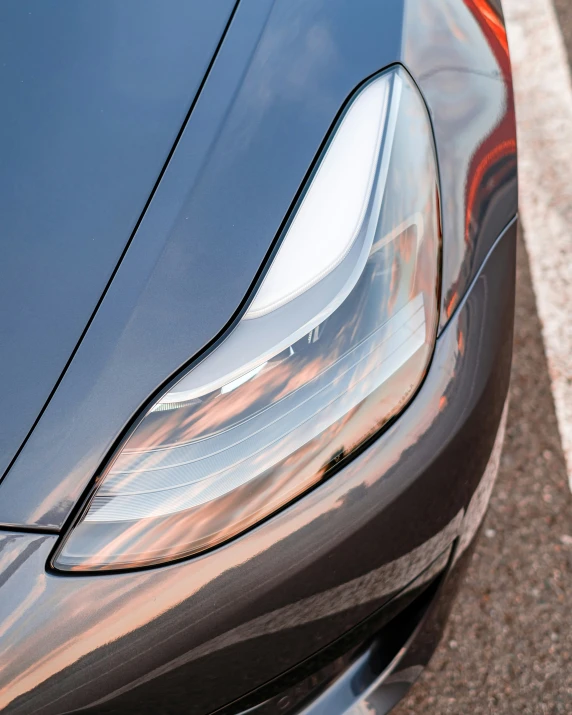 a shiny metallic silver car parked next to a curb