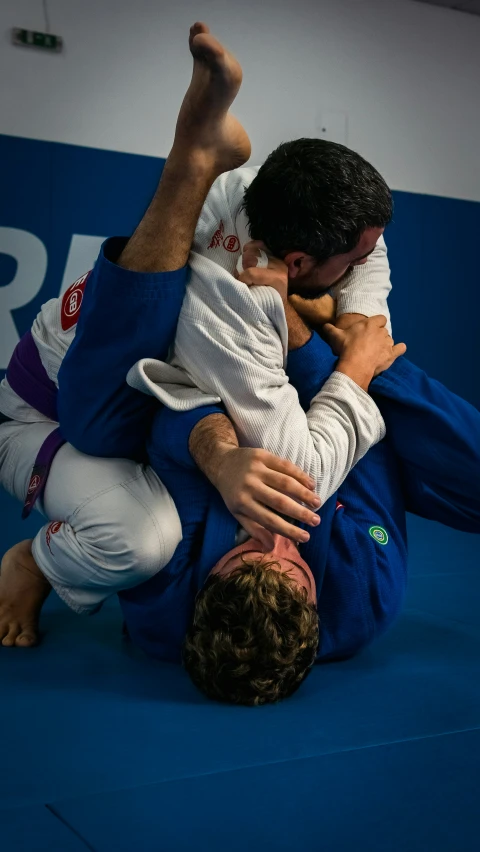 two men are wrestling and one is lifting the other