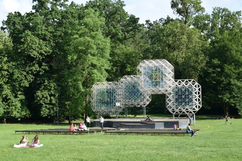 people relaxing at a park with sculptures