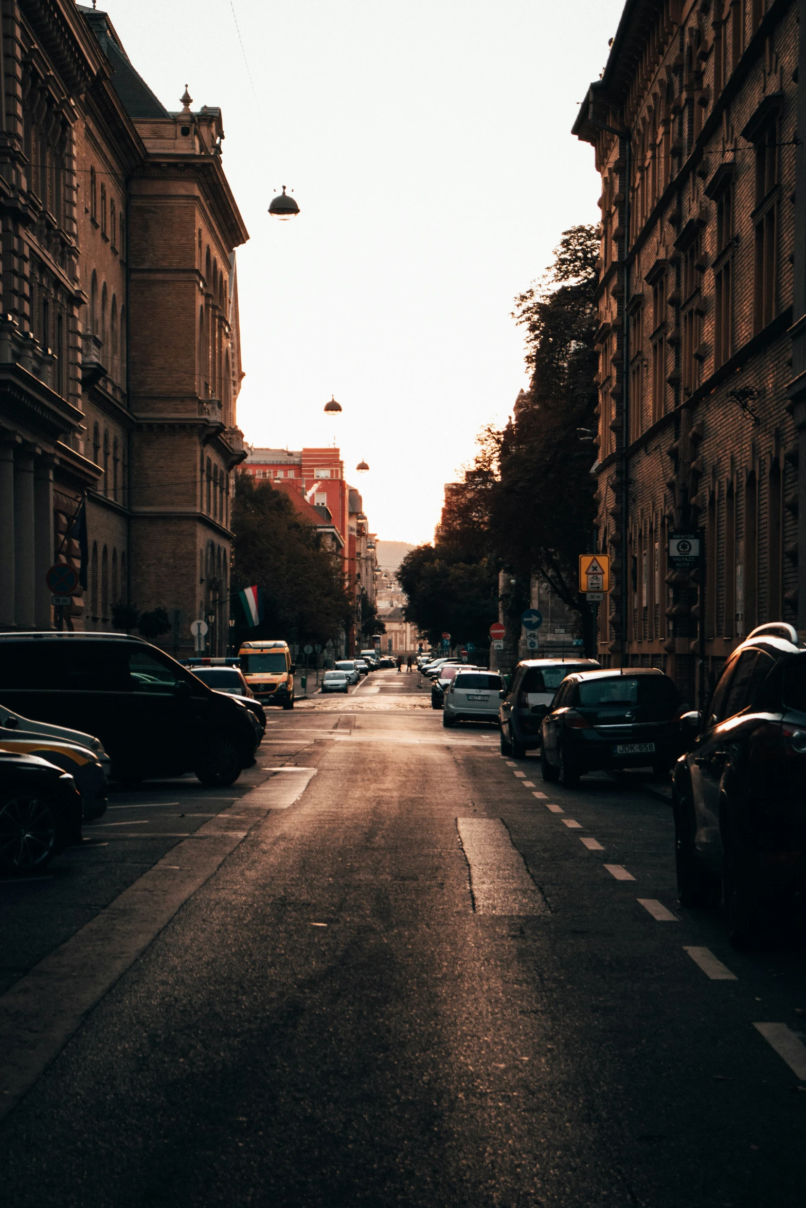 cars on the road in an older european city