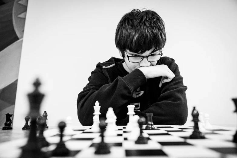 a boy sitting at a chess board