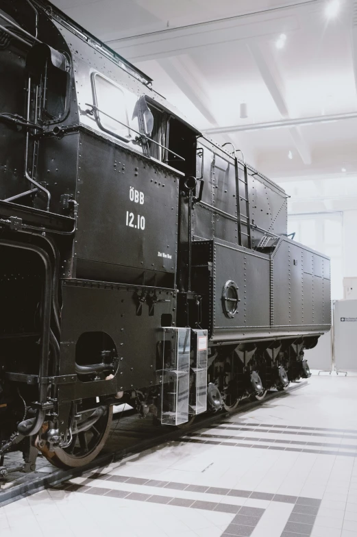 a black locomotive car on display inside of a building