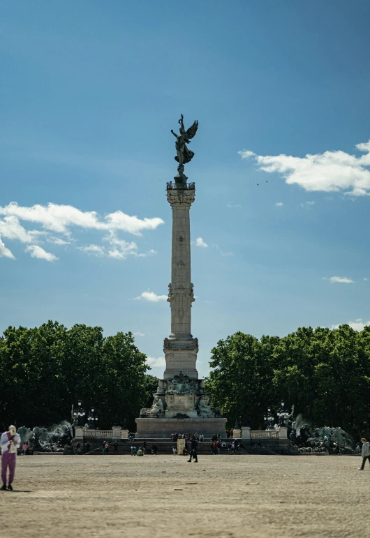 the large statue has two people walking by