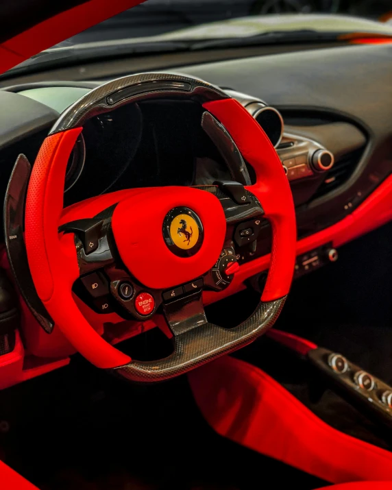 the inside of a sports car, with a leather steering wheel and red seats