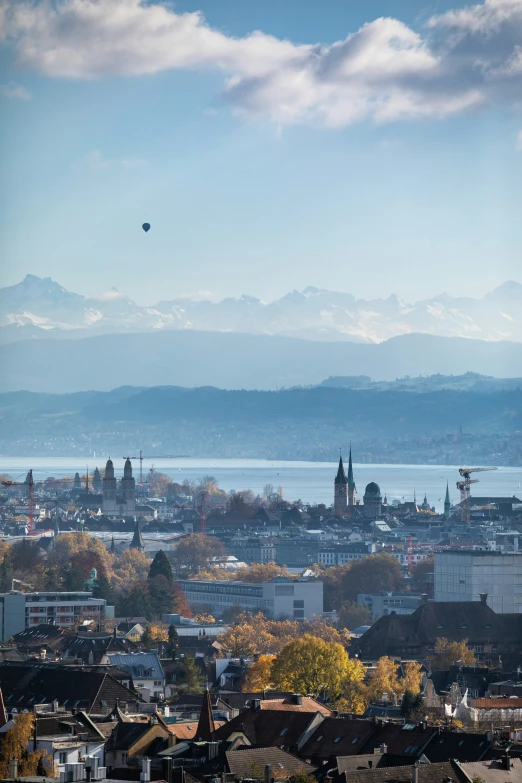 a view of the city and lake, with mountains in the background