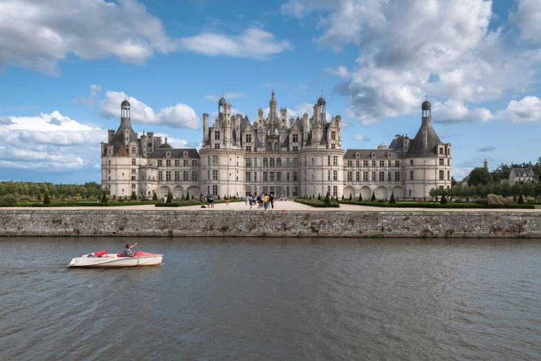 an old castle is shown with boats in the water