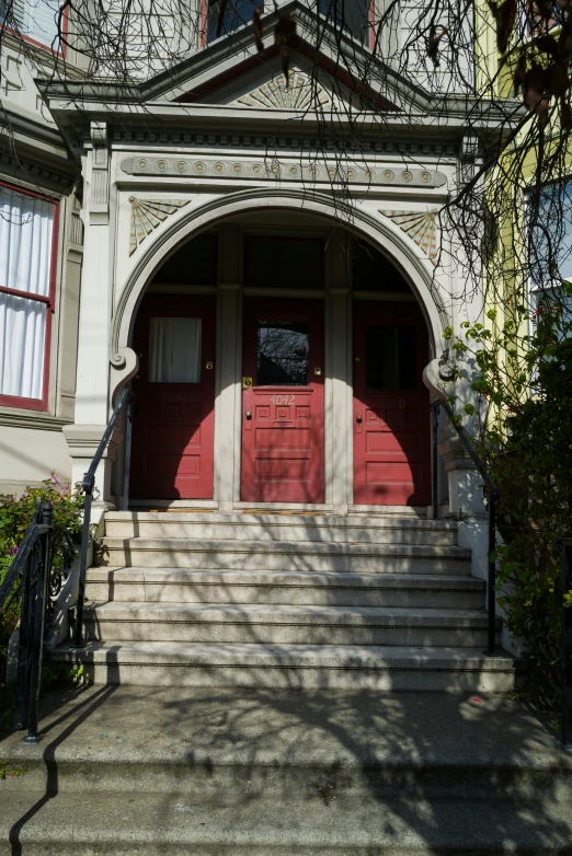 red door and steps in front of a gray building