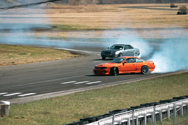 two cars with smoke coming out of their wheels